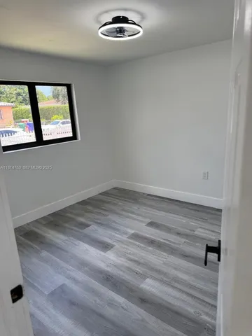 a view of a livingroom with wooden floor and window
