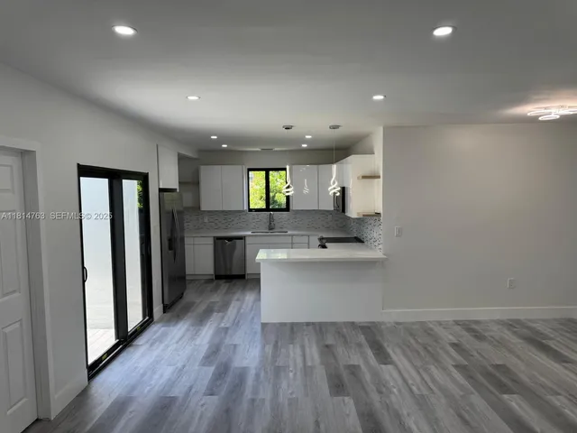 a kitchen with kitchen island a sink stainless steel appliances and cabinets