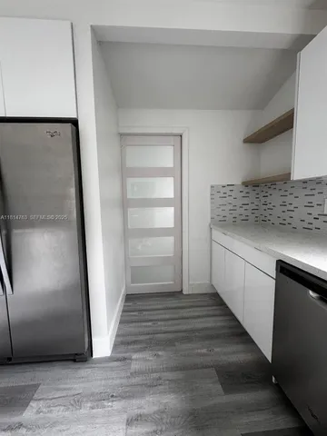 a kitchen with granite countertop a refrigerator and a sink