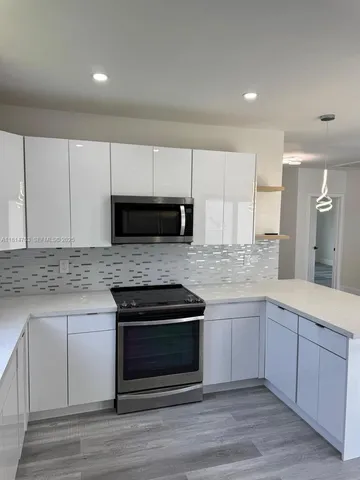 a kitchen with stainless steel appliances granite countertop a stove and a sink