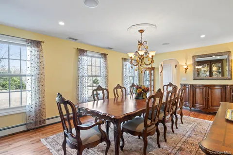 a dining room with furniture a chandelier and wooden floor