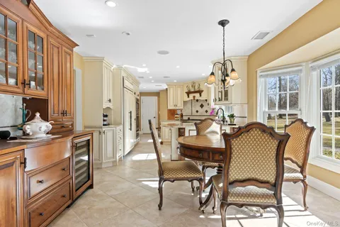 a view of a dining room and livingroom with furniture wooden floor a chandelier
