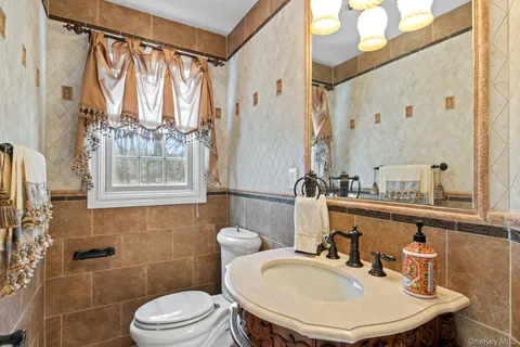 a bathroom with a sink a toilet and a mirror