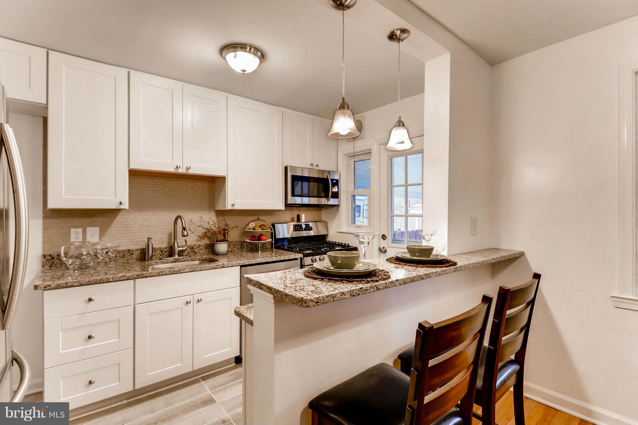 8405 Kavanagh Road Baltimore, MD 21222 - Photo 1 of 30 a kitchen with a stove a sink a dining table and chairs