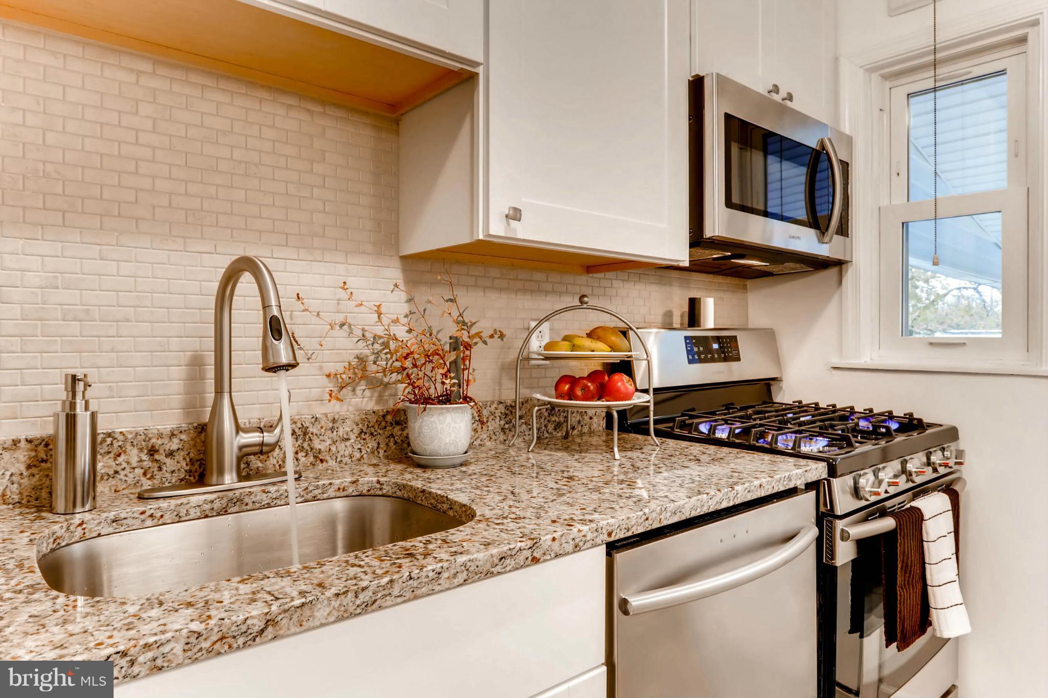 8405 Kavanagh Road Baltimore, MD 21222 - Photo 11 of 30 a kitchen with a sink a stove and cabinets