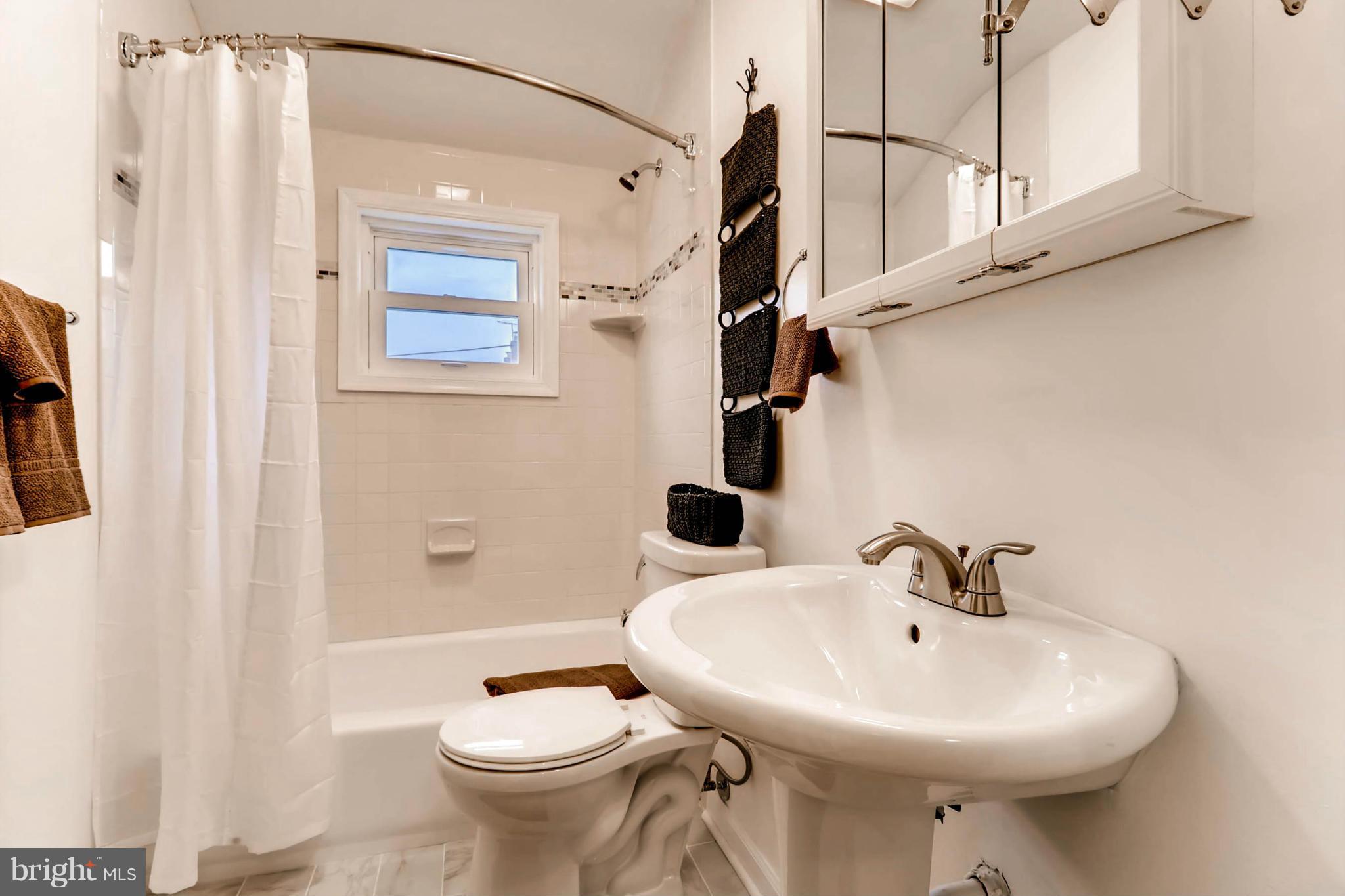 8405 Kavanagh Road Baltimore, MD 21222 - Photo 22 of 30 a bathroom with a sink a toilet and shower