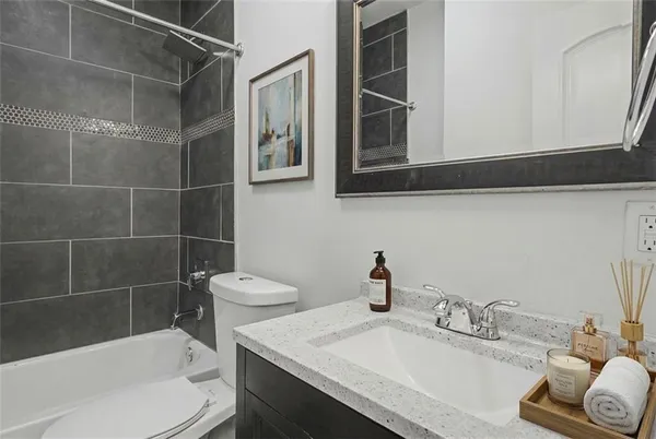 a bathroom with a granite countertop sink toilet and shower