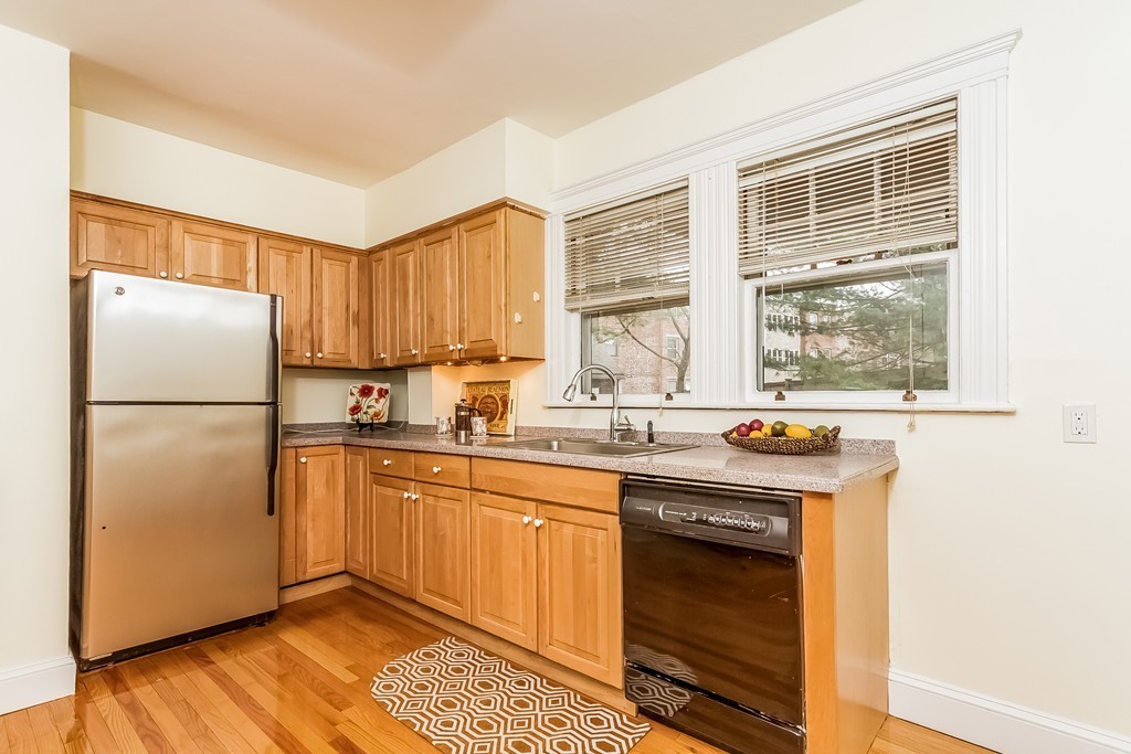 20 Buckminster Road, Unit 1 Brookline, MA 02445 - Photo 6 of 16 a kitchen with granite countertop a refrigerator a sink and a stove