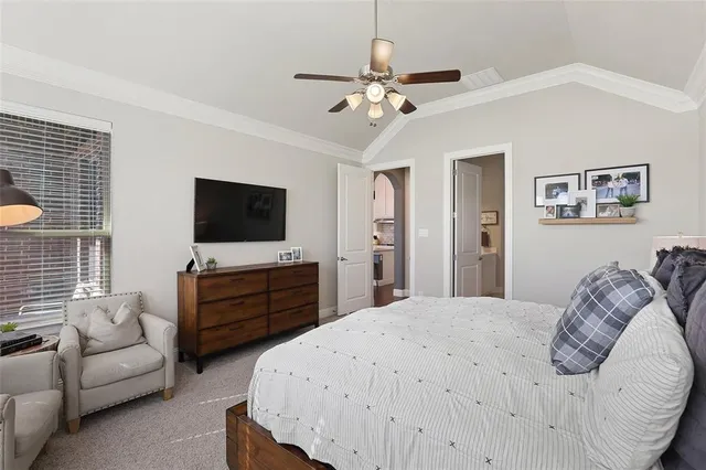 a spacious bedroom with a bed a window and a chandelier