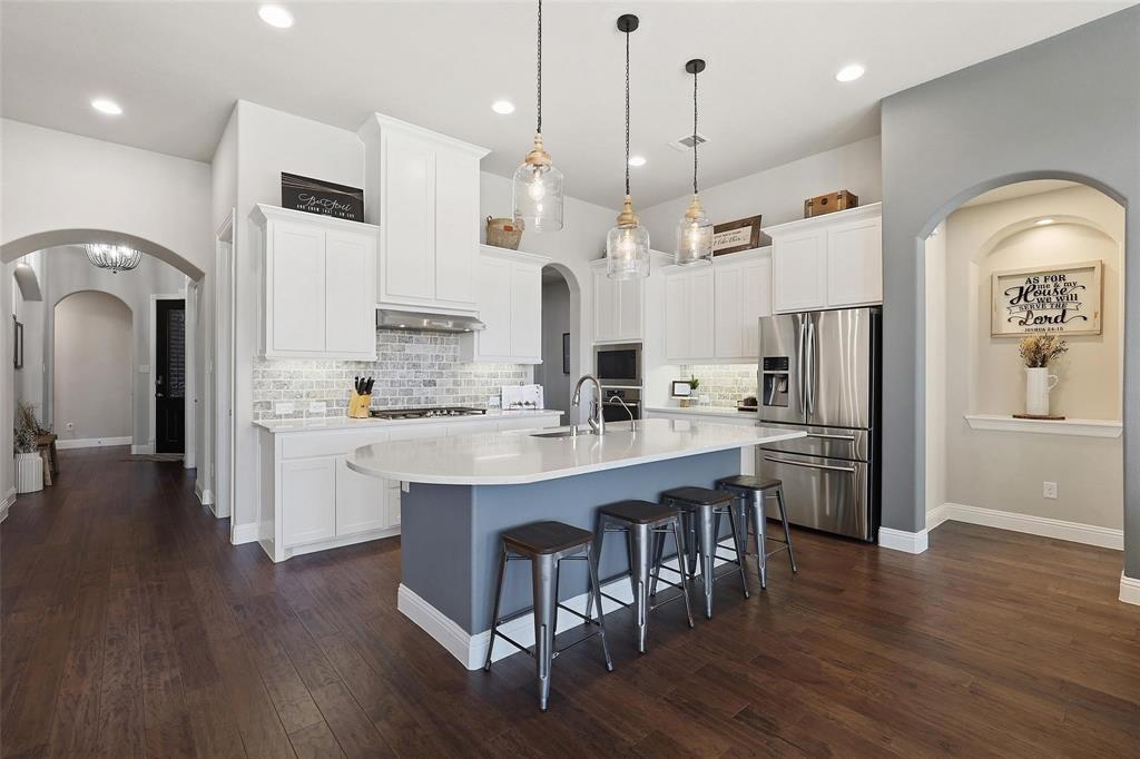 1111 Belknap Way Prosper, TX 75078 - Photo 4 of 24 Kitchen featuring arched walkways, stainless steel appliances, white cabinetry, and recessed lighting