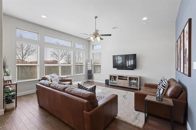 a living room with furniture a large window and a chandelier