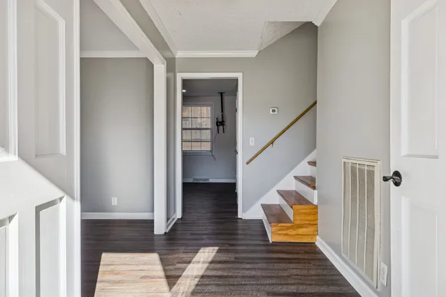 a view of a hallway with wooden floor and staircase
