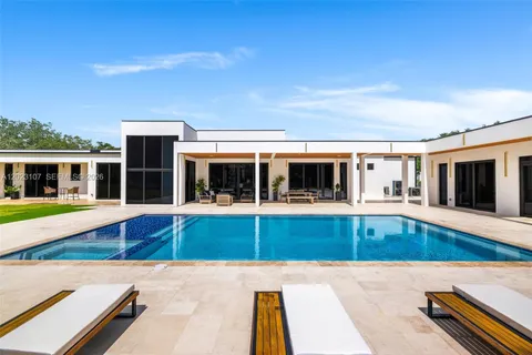 a view of a house with swimming pool and sitting area