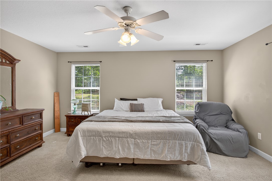 151 Towne Creek Trail Anderson, SC 29621 - Photo 16 of 49 Well-lit sleeping quarters feature soft carpeting and a ceiling fan, ensuring comfort year-round.
