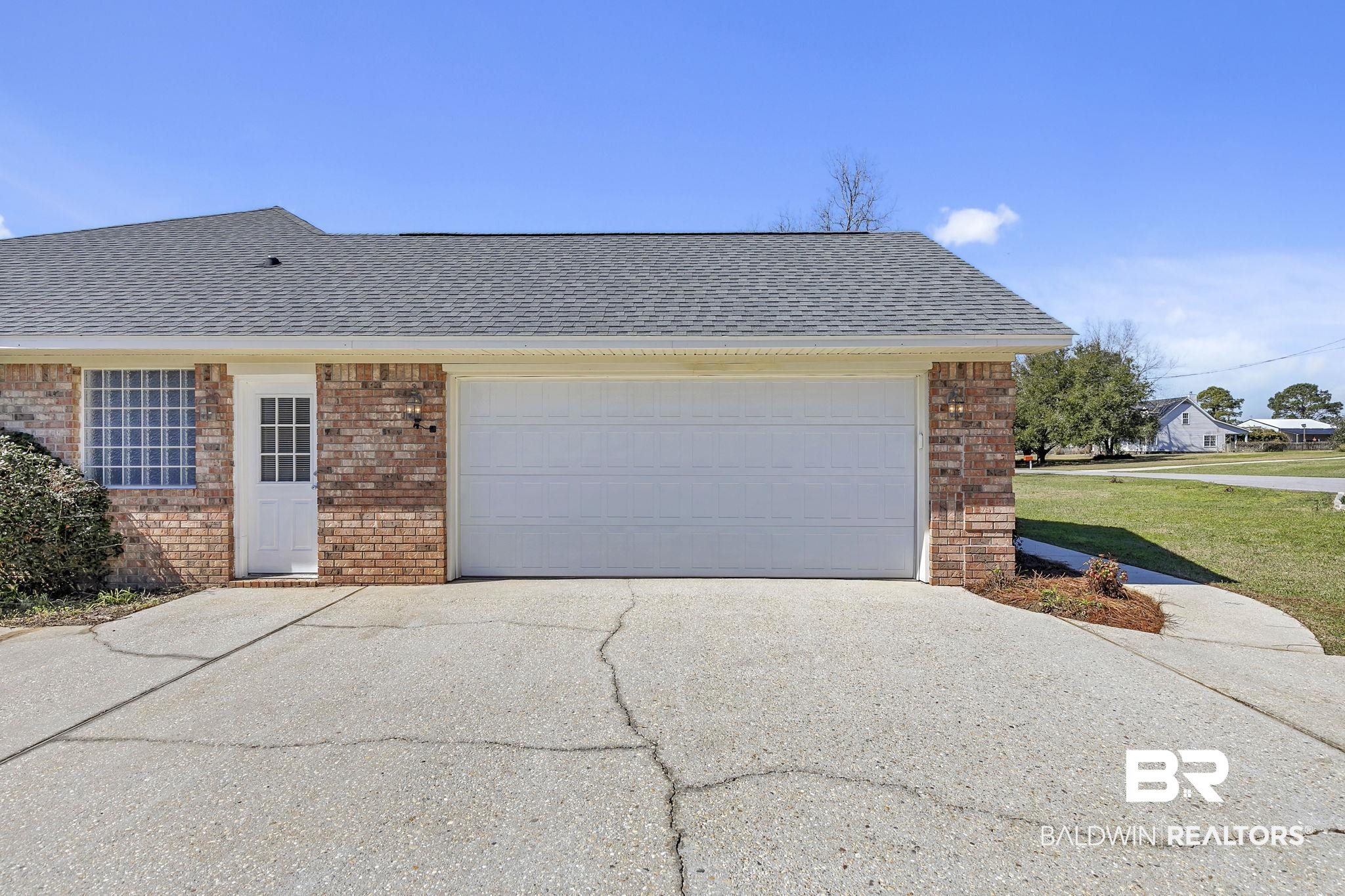 10238 Grove Drive Fairhope, AL 36532 - Photo 5 of 39 View of front facade with a garage, a shingled roof, asphalt driveway, and brick siding