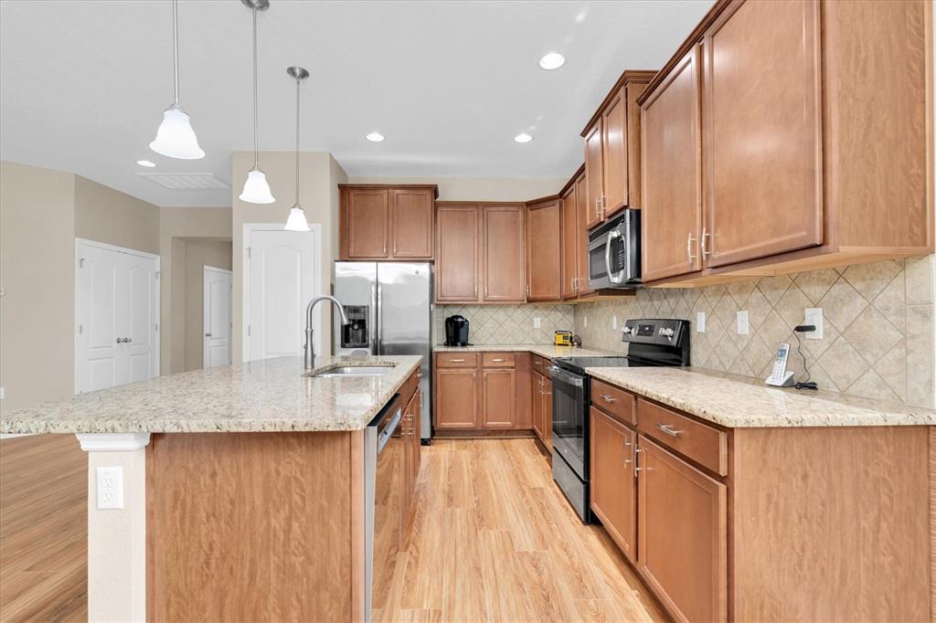 11236 Merganser Way New Port Richey, FL 34654 - Photo 7 of 41 a kitchen with granite countertop a sink a counter space appliances and cabinets