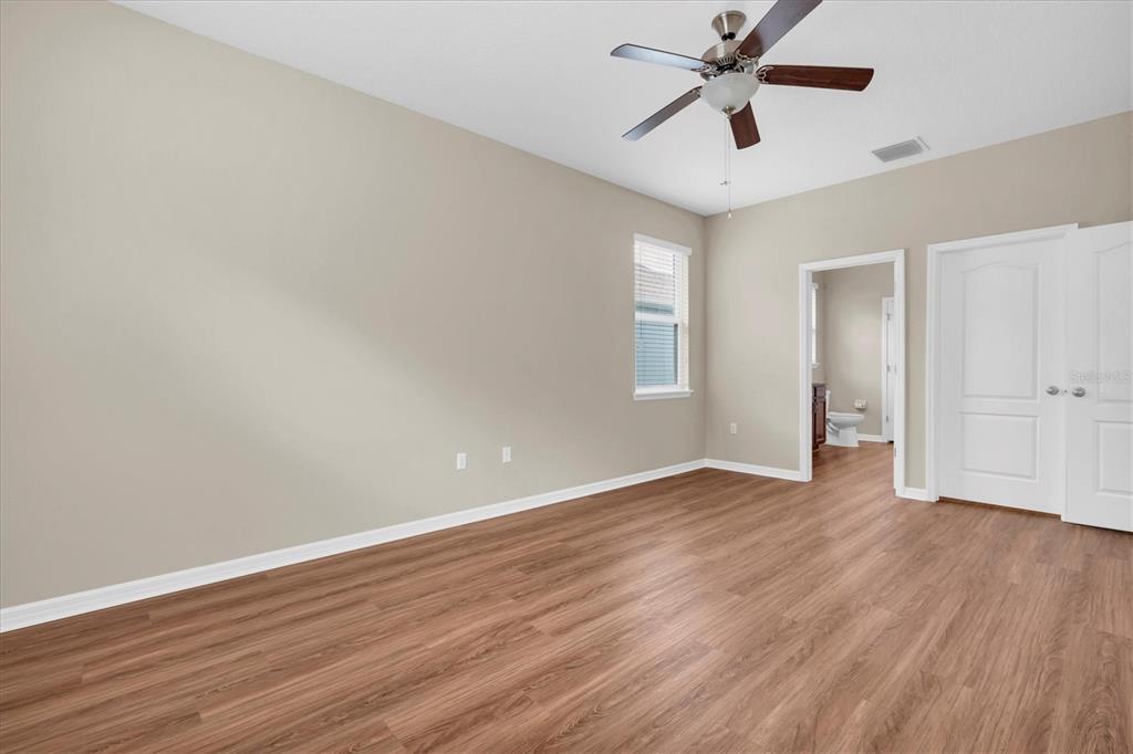 11236 Merganser Way New Port Richey, FL 34654 - Photo 9 of 41 an empty room with wooden floor ceiling fan and windows