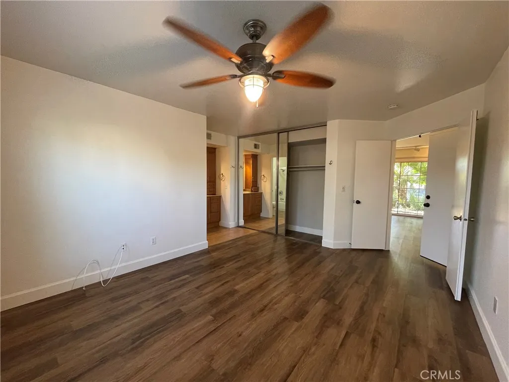 12555 Euclid Street, Unit 21 Garden Grove, CA 92843 - Photo 5 of 7 a view of an empty room with wooden floor and a ceiling fan