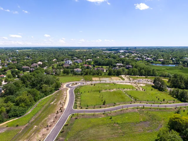 an aerial view of a house with swimming pool and lake view