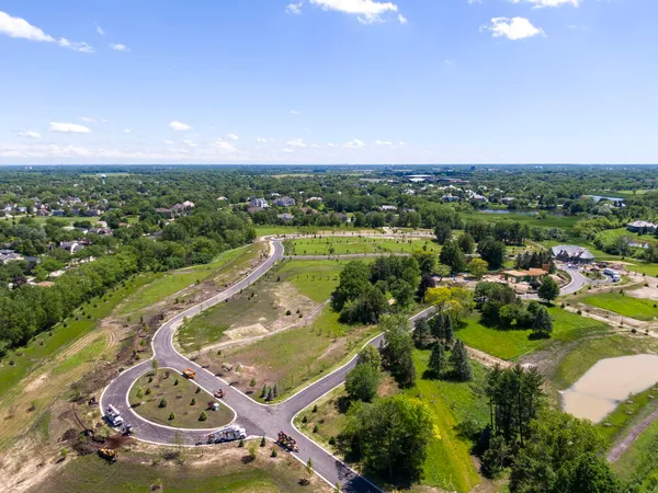 an aerial view of residential houses with outdoor space and trees