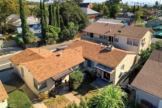 an aerial view of a house with swimming pool and large trees