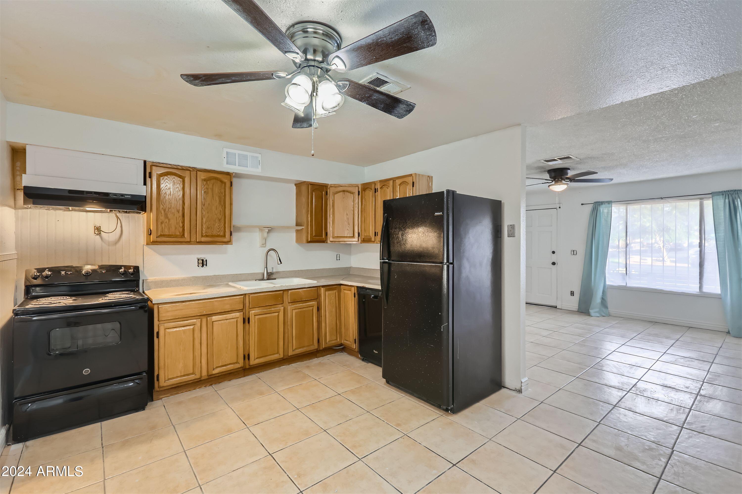 5202 West Berkeley Road Phoenix, AZ 85035 - Photo 5 of 12 a kitchen with stainless steel appliances granite countertop a refrigerator a sink a stove top oven and a dishwasher