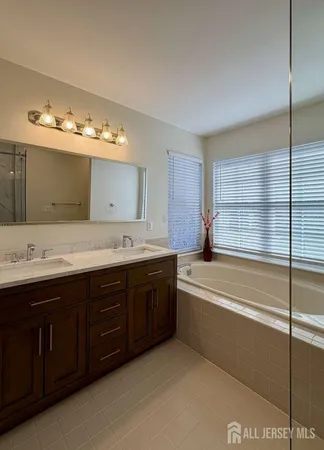 a bathroom with a tub sink and mirror