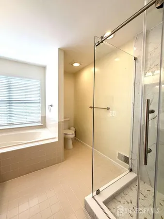 a bathroom with a glass shower door and a window