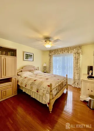 a spacious bedroom with a bed and wooden floor