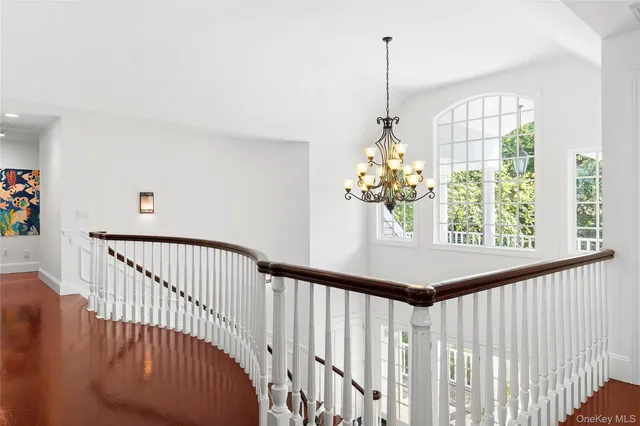 a view of a hallway with windows and chandelier