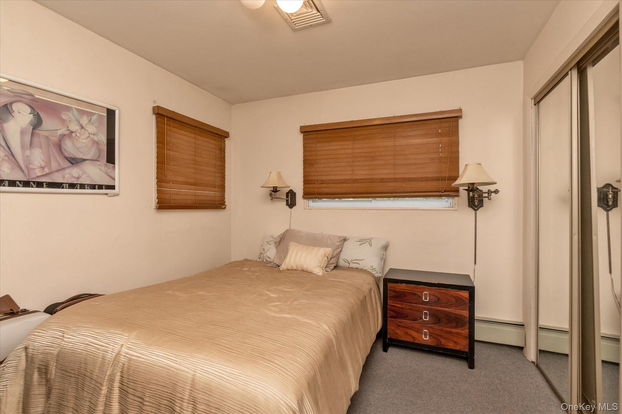 1055 Cedarhurst Street Valley Stream, NY 11581 - Photo 16 of 27 a bedroom with a bed and a wall painting