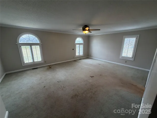 an empty room with windows and cabinet