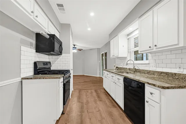 a view of a kitchen with wooden floor and windows