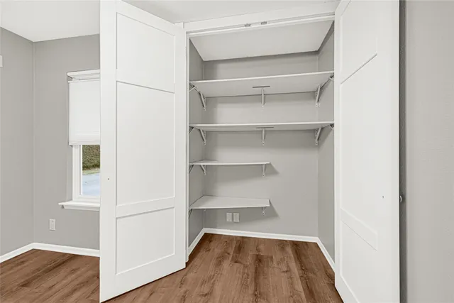 a view of walk in closet with empty racks