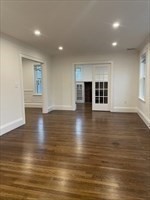 55 Dalton Road, Unit 1 Belmont, MA 02478 - Photo 2 of 16 an empty room with wooden floor and windows