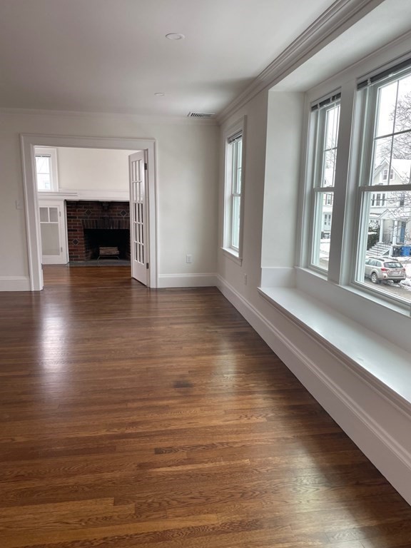 55 Dalton Road, Unit 1 Belmont, MA 02478 - Photo 3 of 16 an empty room with wooden floor and windows