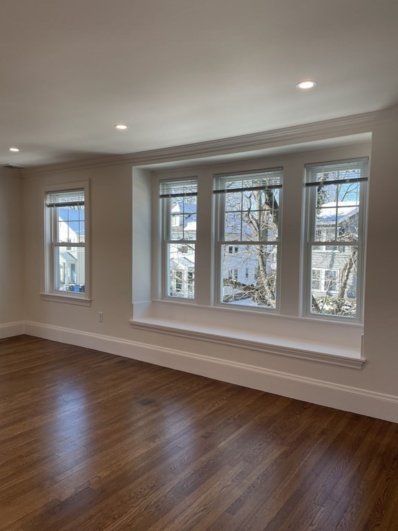 55 Dalton Road, Unit 1 Belmont, MA 02478 - Photo 4 of 16 an empty room with wooden floor and windows