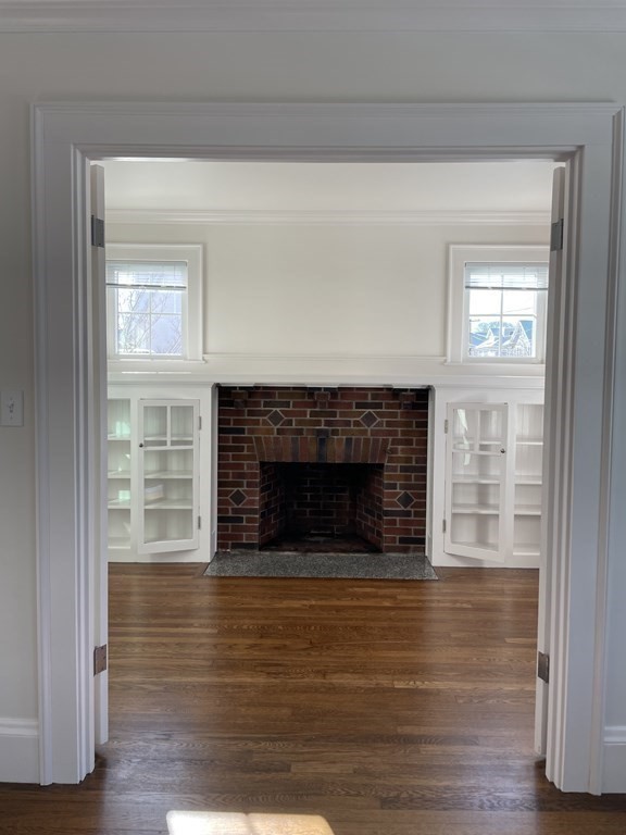 55 Dalton Road, Unit 1 Belmont, MA 02478 - Photo 5 of 16 a view of an empty room with wooden floor fireplace and a window