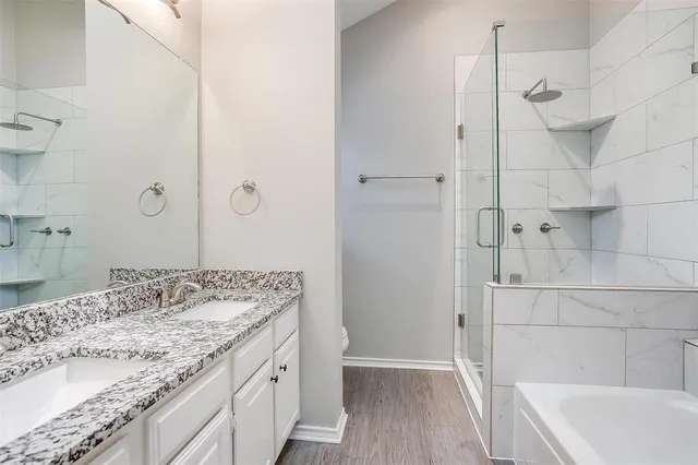 a bathroom with a granite countertop sink a toilet and shower