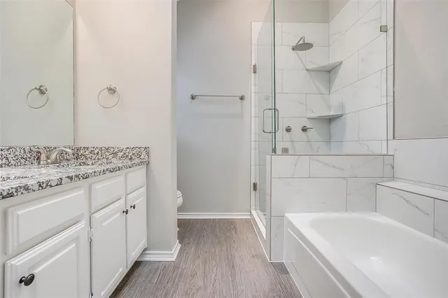 a bathroom with a granite countertop sink a toilet and bathtub