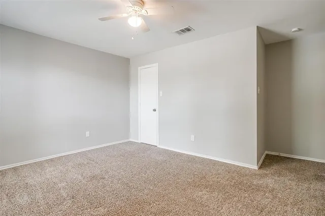 a view of an empty room with a chandelier fan