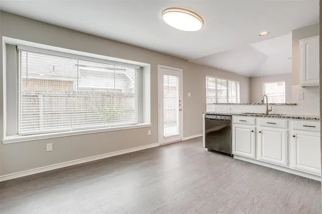 a kitchen with granite countertop white cabinets and white appliances