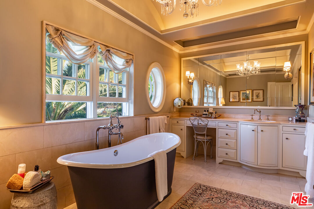 685 Elkins Road Los Angeles, CA 90049 - Photo 15 of 24 a bathroom with a sink a bathtub and a mirror