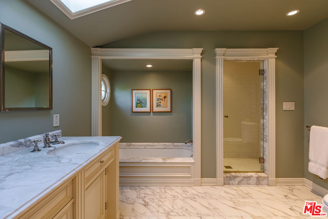 685 Elkins Road Los Angeles, CA 90049 - Photo 17 of 24 a bathroom with a granite countertop sink and a mirror