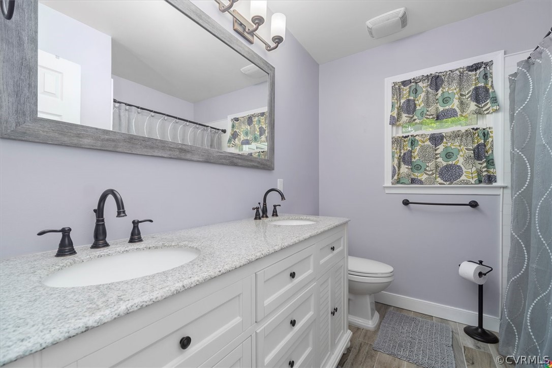 10211 Robbie Road Chesterfield, VA 23832 - Photo 27 of 50 a bathroom with a granite countertop sink a toilet and a mirror