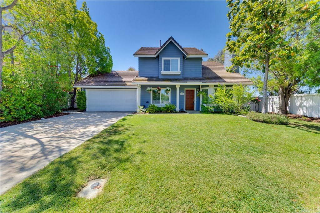 a view of a house with a big yard and large trees
