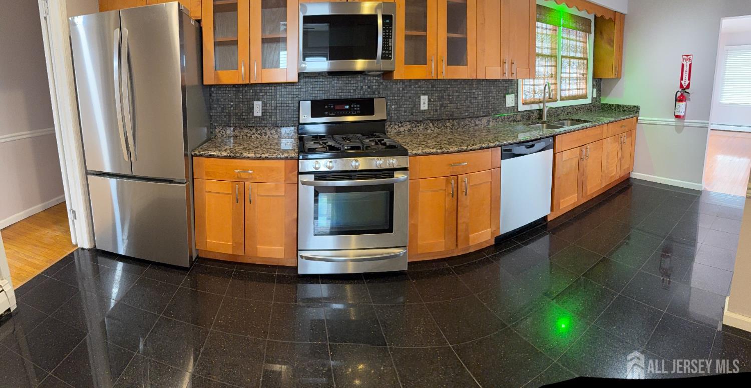 134 Oak Street, Unit 1 Rahway, NJ 07065 - Photo 4 of 16 a kitchen with stainless steel appliances granite countertop a sink and a stove