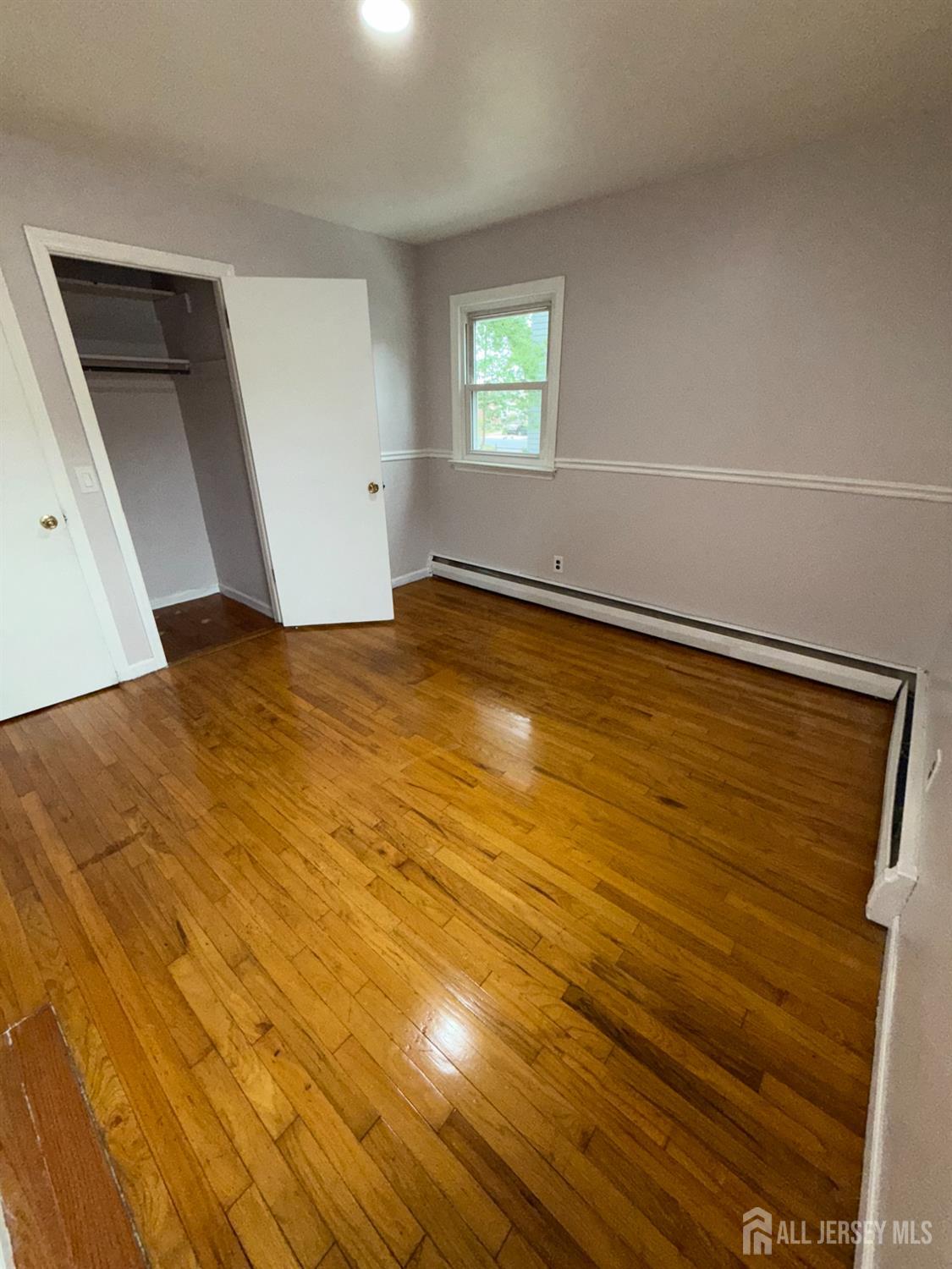 134 Oak Street, Unit 1 Rahway, NJ 07065 - Photo 10 of 16 a view of empty room with window and wooden floor