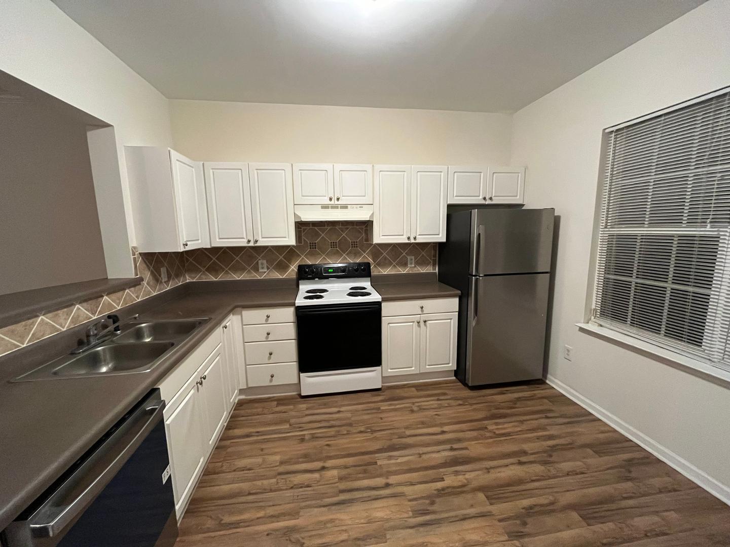 156 Blue Crest Lane Durham, NC 27705 - Photo 5 of 13 a kitchen with a refrigerator a stove top oven and a counter space