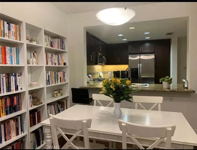 a kitchen with a table chairs and a living room